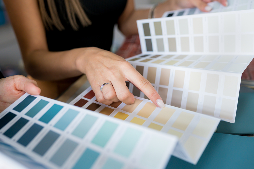 Close-up,Of,Two,Women,Choosing,Samples,Of,Wall,Paint.,Interior Tips For Choosing Interior Paint Colors